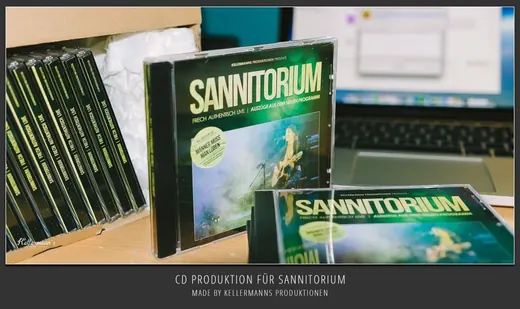 CDs von SANNITORIUM auf einem Schreibtisch mit einem Laptop im Hintergrund, produziert von